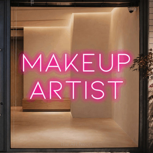 Hot pink LED neon sign reading "Makeup Artist" against a warm beige alcove wall for salon décor