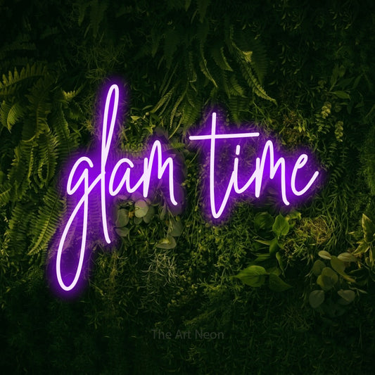 Purple script-style LED neon sign reading "Glam Time" against a moss-covered green wall for salon décor