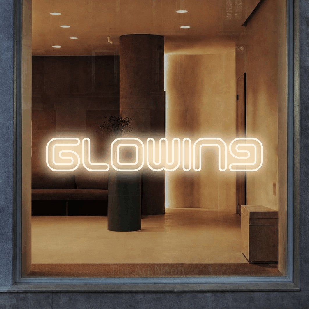 Warm white outline-style LED neon sign reading "Glowing" in a warm modern interior for salon décor