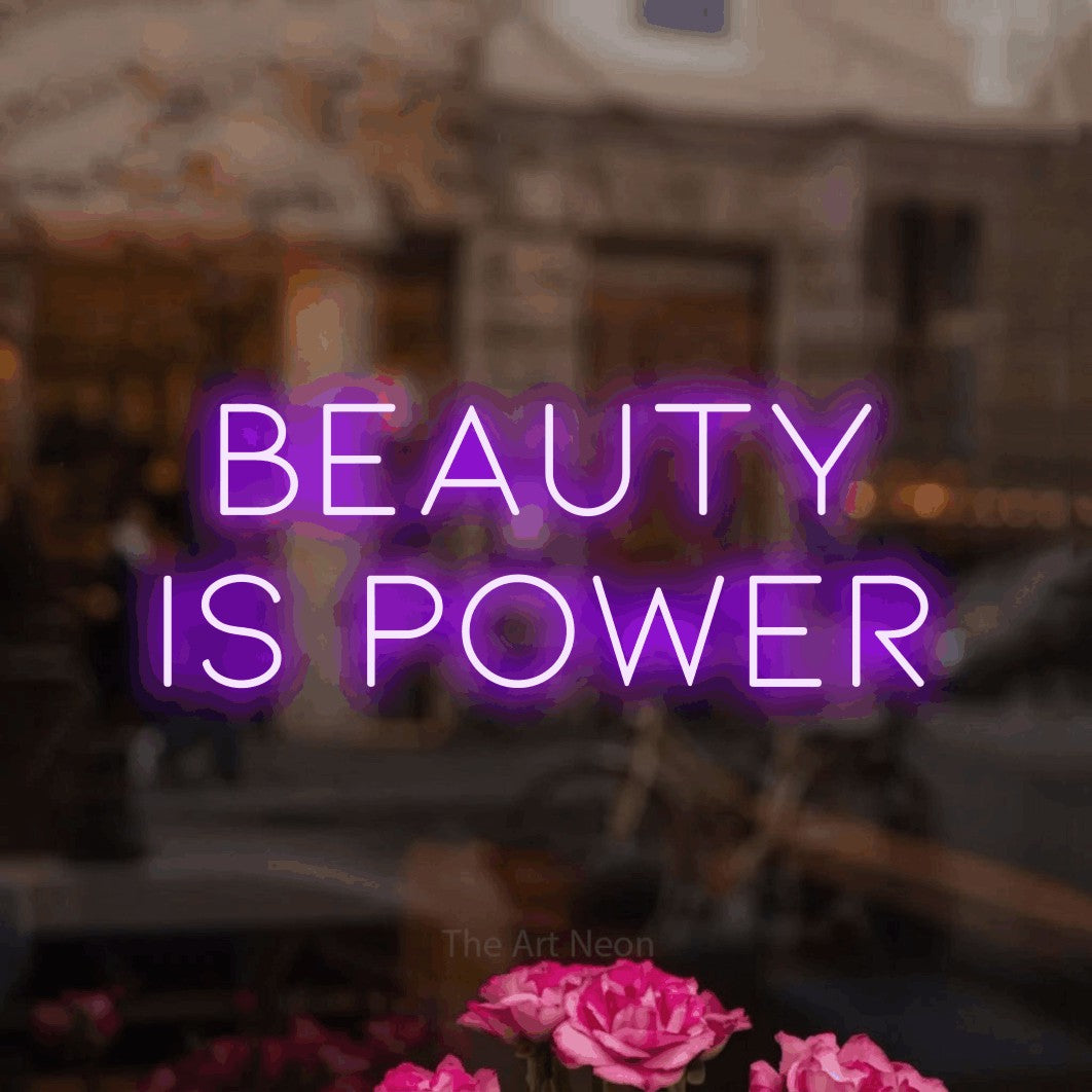 Purple LED neon sign reading "Beauty is Power" in a softly blurred café interior for salon décor