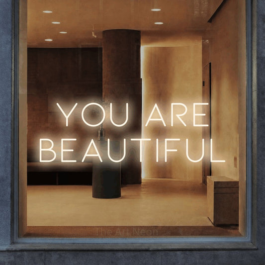 Warm white LED neon sign reading "You Are Beautiful" in a warm modern interior for salon décor