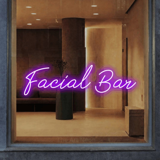 Purple script-style LED neon sign reading "Facial Bar" in a warm modern interior for salon décor