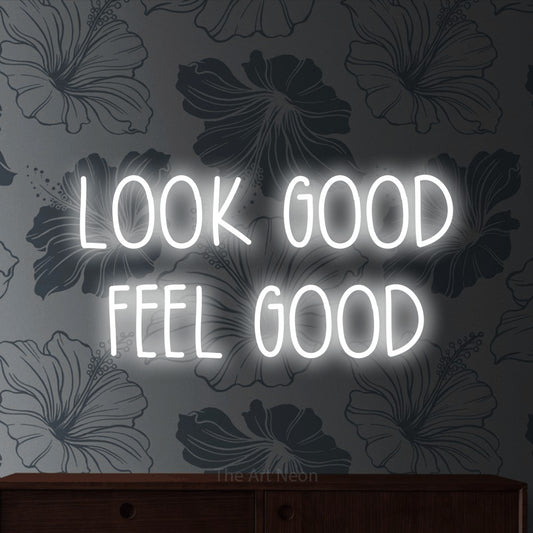 Cool white LED neon sign reading "Look Good Feel Good" against grey floral wallpaper for salon décor