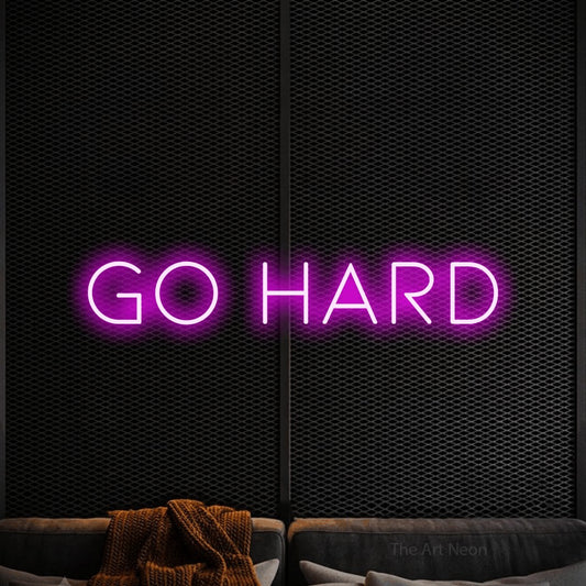 Enseigne néon à DEL à lumière rose, affichant « Go Hard » sur un mur noir texturé, pour décorer une salle d’entraînement