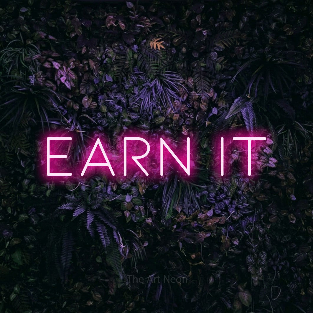 Hot pink LED neon sign reading "Earn It" against a purple floral wall for gym décor