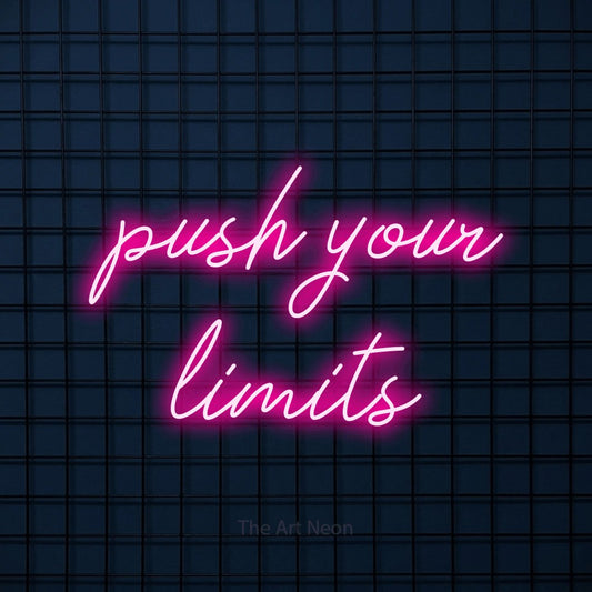 Hot pink script-style LED neon sign reading "Push Your Limits" against a dark blue tiled wall for gym décor