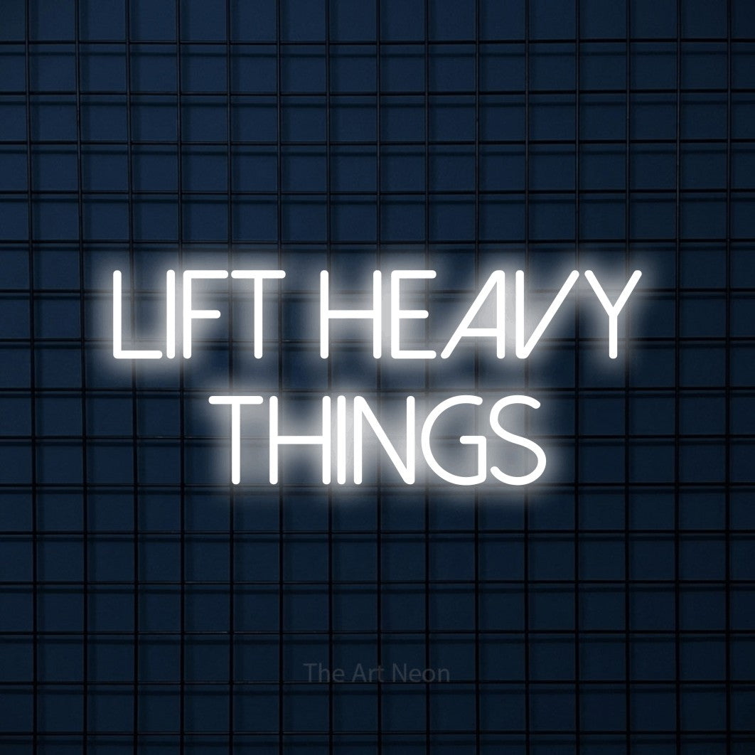 Enseigne néon à DEL à lumière blanche froide, affichant « Lift Heavy Things » sur un mur carrelé bleu foncé, pour décorer une salle d’entraînement