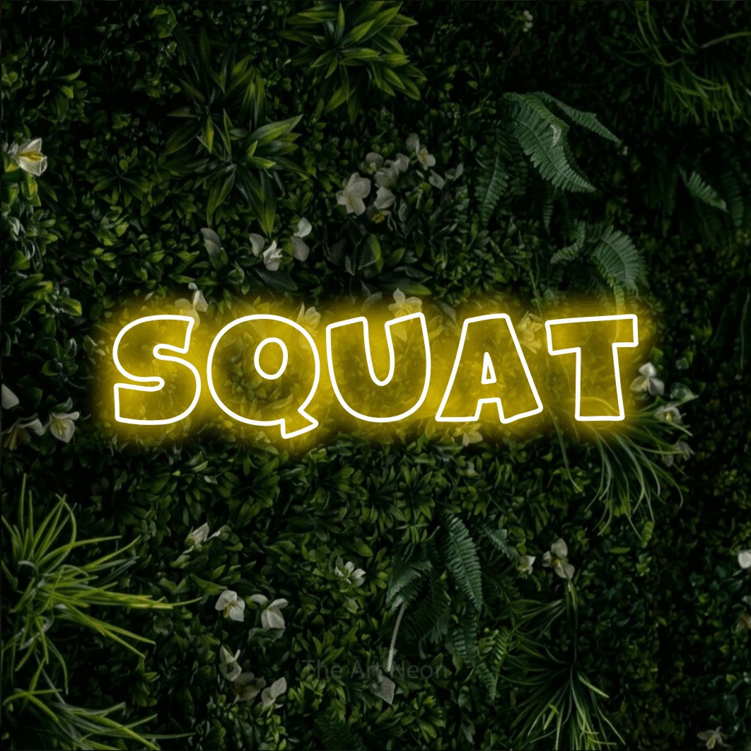 Enseigne néon à DEL à lumière jaune, de style contour, affichant « Squat » sur un mur de feuillage vert, pour décorer une salle d’entraînement