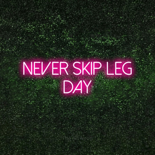 Hot pink LED neon sign reading "Never Skip Leg Day" against a textured green moss wall for gym décor