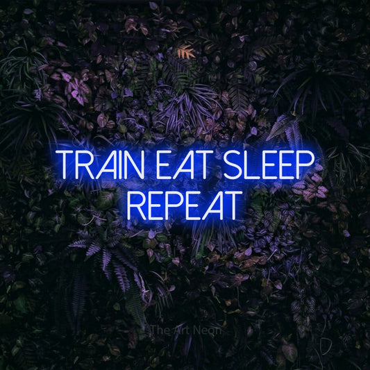 Blue LED neon sign reading "Train Eat Sleep Repeat" against a purple floral wall for gym décor