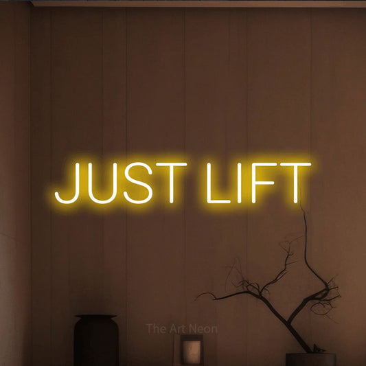 Yellow LED neon sign reading "Just Lift" against a warm brown wall for gym décor