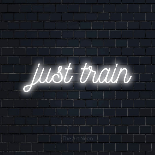 Cool white script-style LED neon sign reading "Just Train" against a dark navy brick wall for gym décor