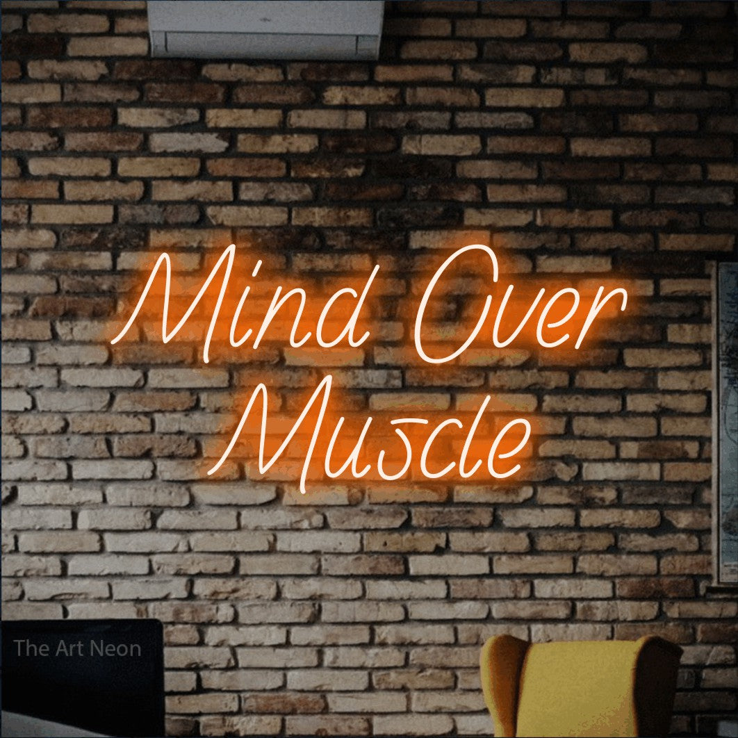 Orange LED neon sign reading "Mind Over Muscle" against a rustic brick wall for gym décor