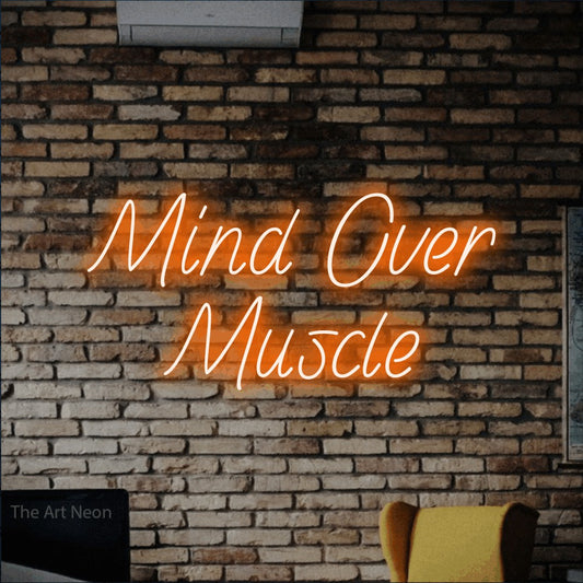 Enseigne néon à DEL à lumière orange, affichant « Mind Over Muscle » sur un mur de briques rustique, pour décorer une salle d’entraînement