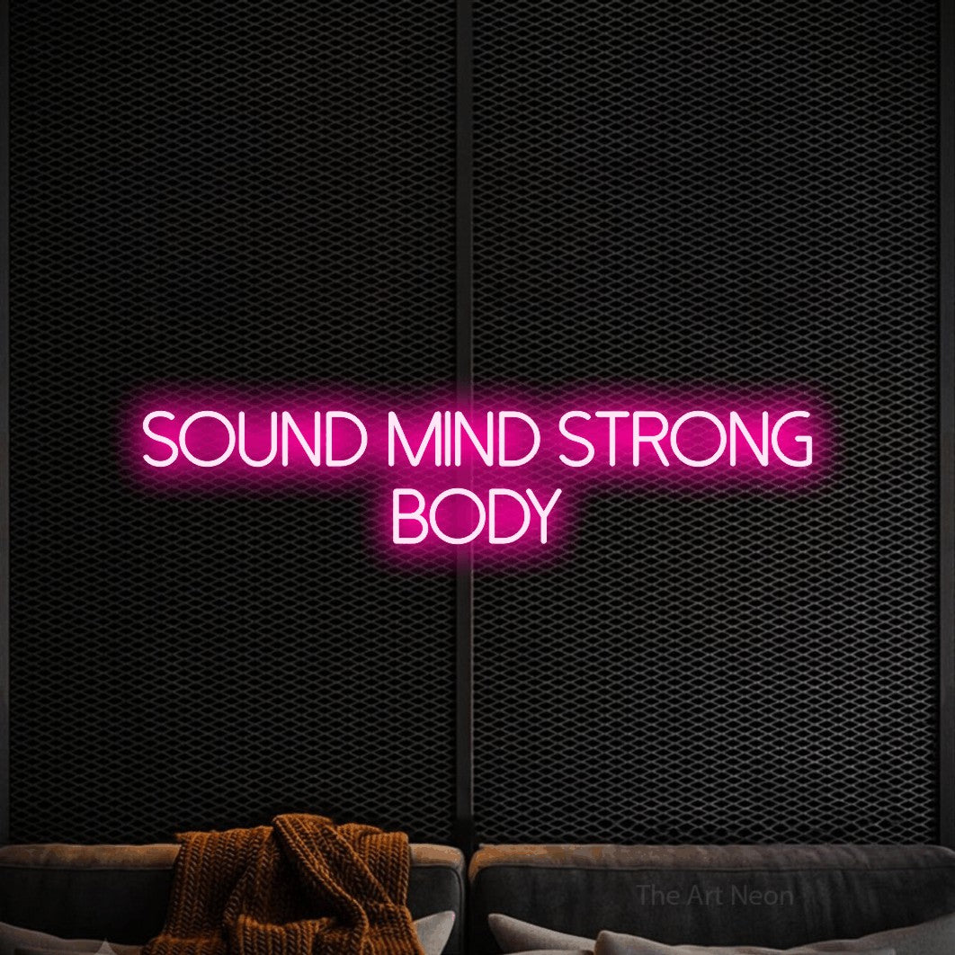 Hot pink LED neon sign reading "Sound Mind Strong Body" against a black textured wall for gym décor