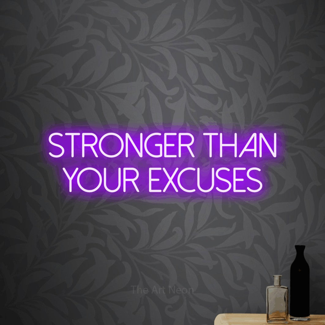Purple LED neon sign reading "Stronger Than Your Excuses" against light grey floral wallpaper for gym décor
