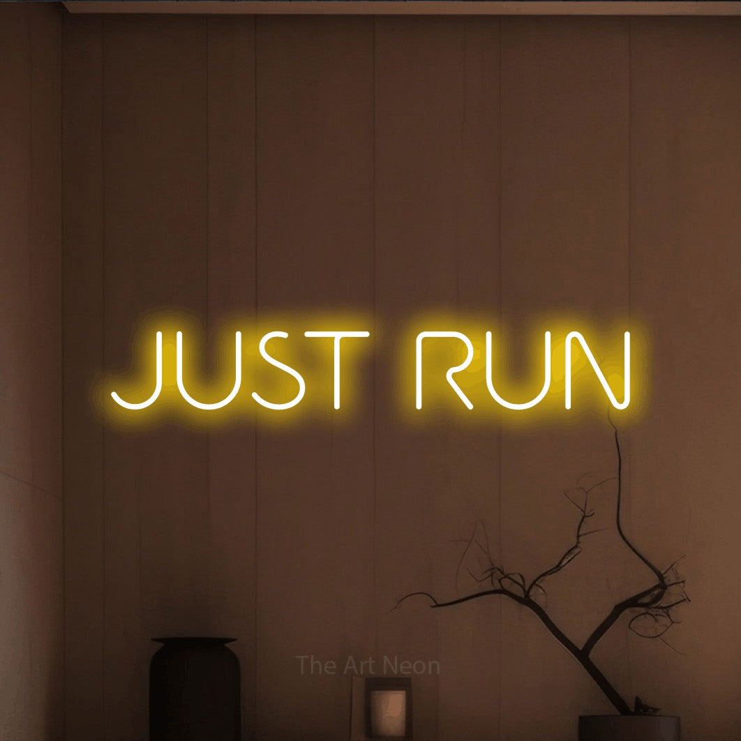 Yellow LED neon sign reading "Just Run" against a warm brown wall for gym décor