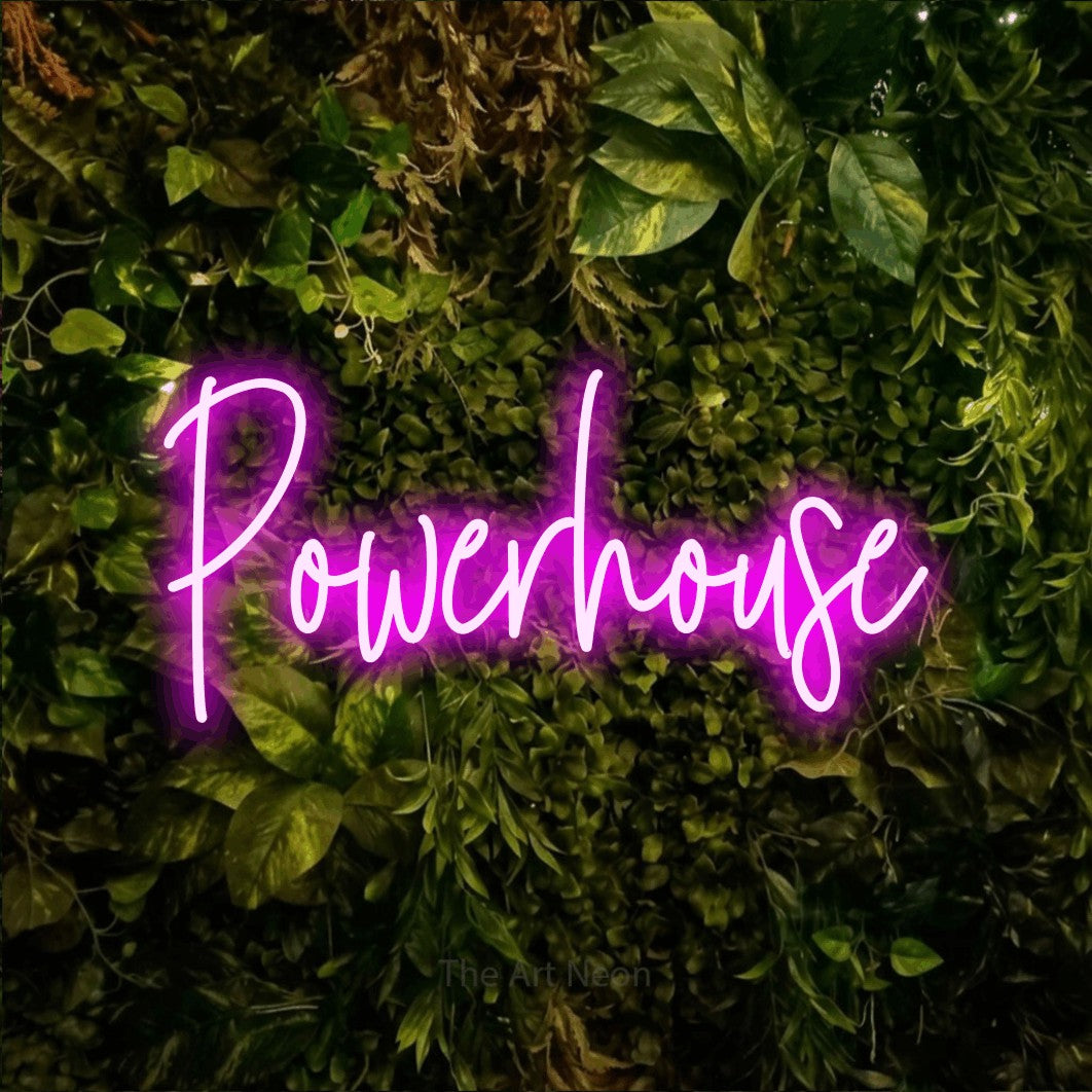 Pink script-style LED neon sign reading "Powerhouse" against a textured moss and foliage wall for gym décor