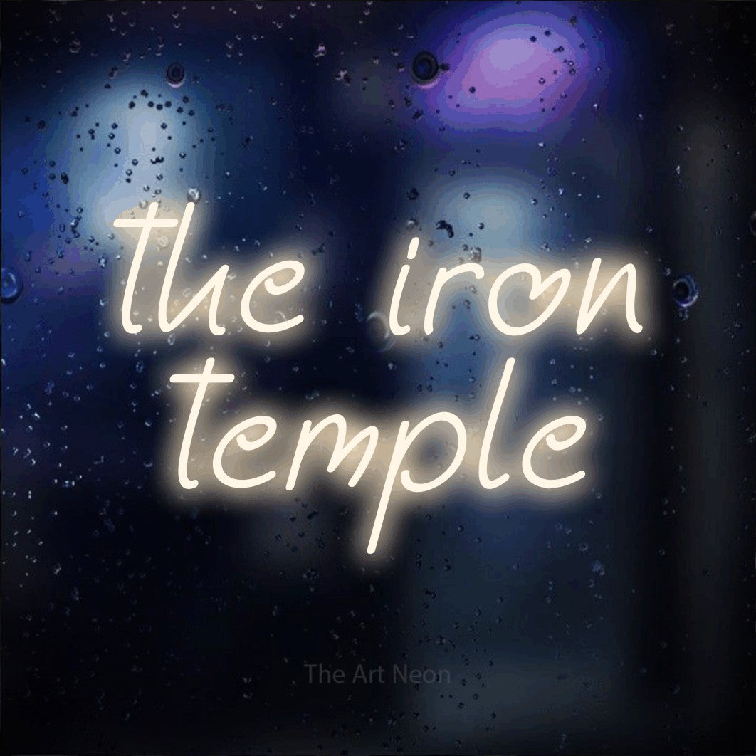 Warm white LED neon sign reading "The Iron Temple" against a dark blue bokeh background for gym décor
