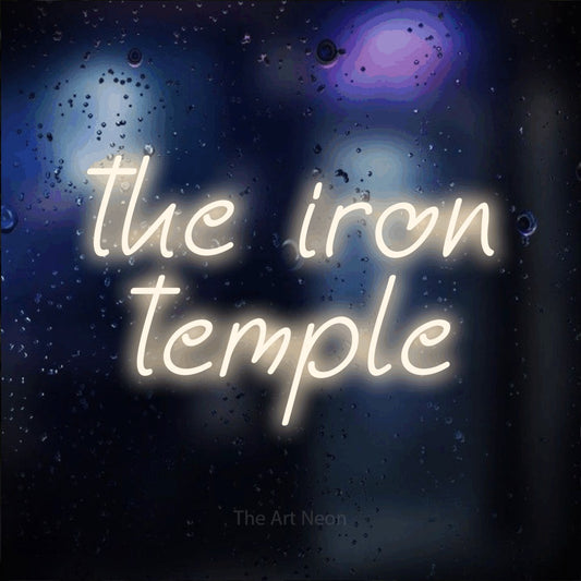Enseigne néon à DEL à lumière blanche chaude, affichant « The Iron Temple » sur un arrière-plan bokeh bleu foncé, pour décorer une salle d’entraînement