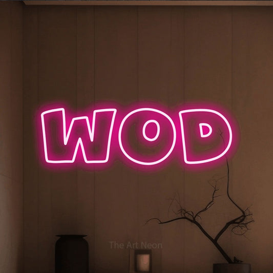 Hot pink outline-style LED neon sign reading "WOD" against a warm brown wall for gym décor