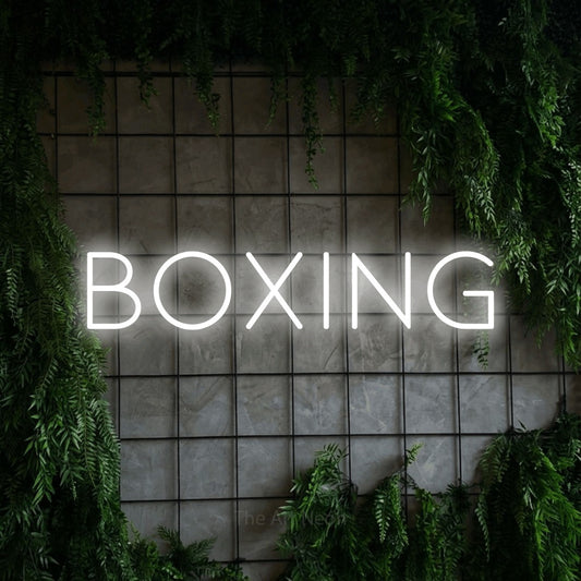 Cool white LED neon sign reading "Boxing" against a green grid wall with foliage for gym décor