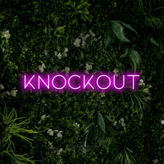 Pink LED neon sign reading "Knockout" against a leafy green wall for gym décor