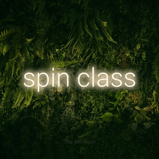 Warm white LED neon sign reading "Spin Class" against a moss-covered green wall for gym décor