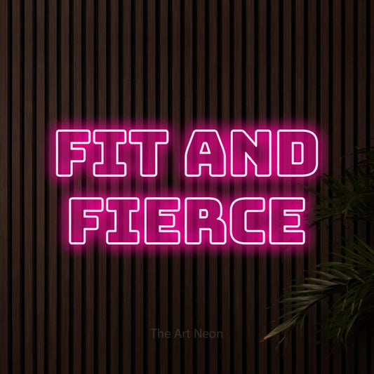 Hot pink outline-style LED neon sign reading "Fit and Fierce" against dark wooden slats for gym décor