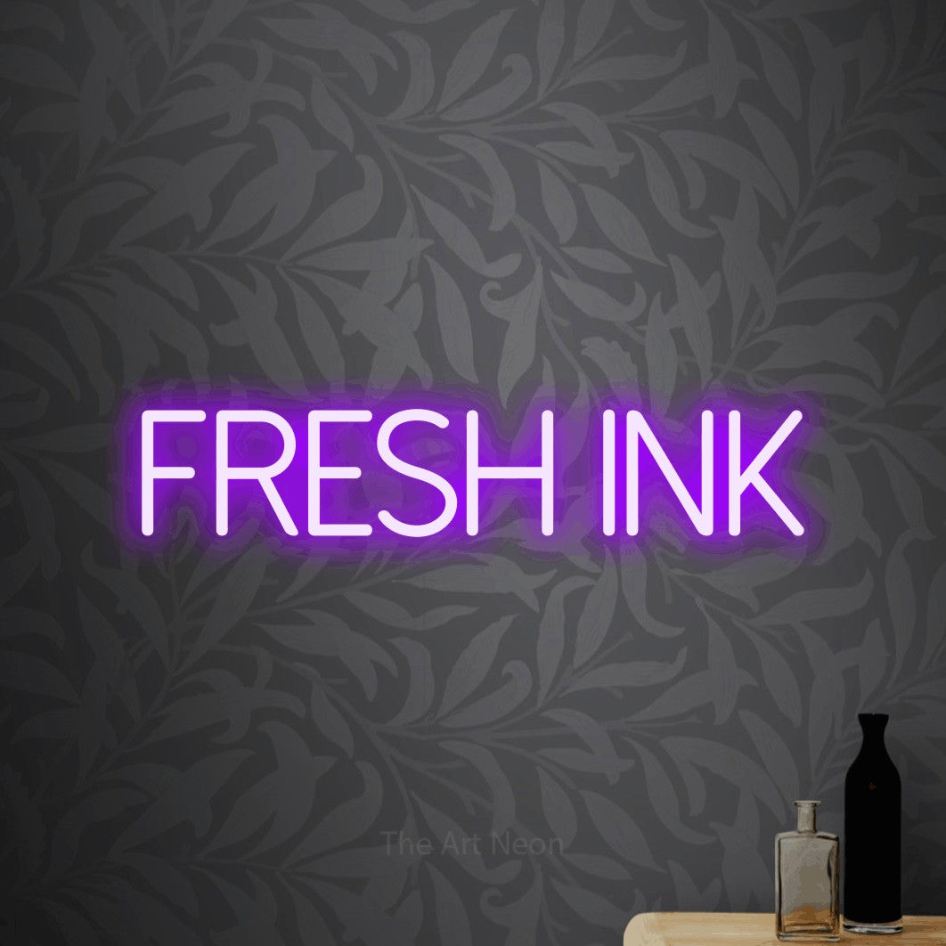 Purple LED neon sign reading "Fresh Ink" against light grey floral wallpaper for tattoo studio décor