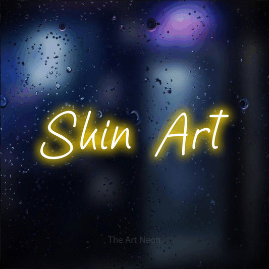 Yellow LED neon sign reading "Skin Art" against a dark blue bokeh background for tattoo studio décor