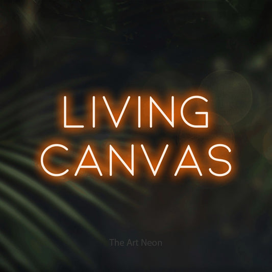 Orange LED neon sign reading "Living Canvas" against dark blurred palm leaves for tattoo studio décor