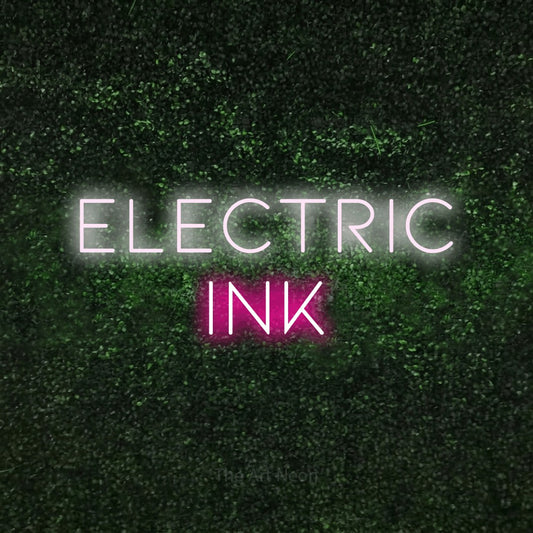 Hot pink and cool white LED neon sign reading "Electric Ink" against a textured green moss wall for tattoo studio décor