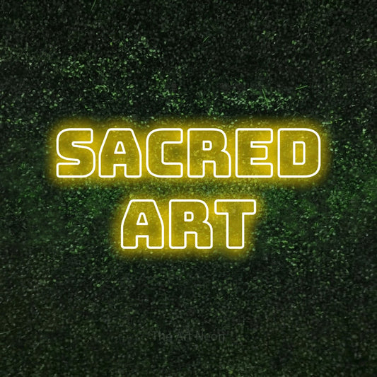 Yellow outline-style LED neon sign reading "Sacred Art" against a textured green moss wall for tattoo studio décor