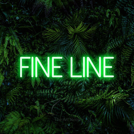 Green LED neon sign reading "Fine Line" against a dense tropical foliage wall for tattoo studio décor