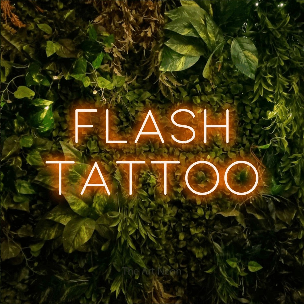 Orange LED neon sign reading "Flash Tattoo" against a textured moss and foliage wall for tattoo studio décor