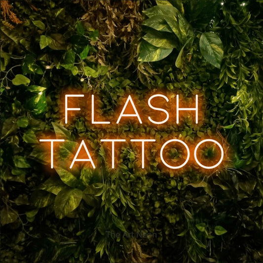 Orange LED neon sign reading "Flash Tattoo" against a textured moss and foliage wall for tattoo studio décor