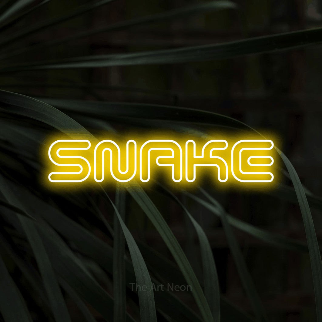 Yellow outline-style LED neon sign reading "Snake" against dark tropical leaves for tattoo studio décor