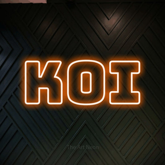 Orange outline-style LED neon sign reading "Koi" against a dark geometric wood wall for tattoo studio décor