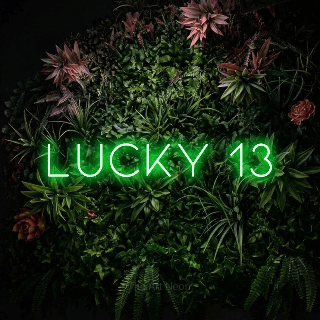 Green LED neon sign reading "Lucky 13" against a flowering garden wall for tattoo studio décor