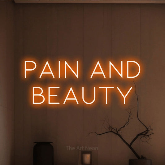 Orange LED neon sign reading "Pain and Beauty" against a warm brown wall for tattoo studio décor