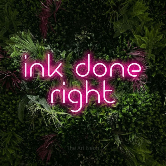 Hot pink LED neon sign reading "Ink Done Right" against a lush garden wall with pink flowers for tattoo studio décor