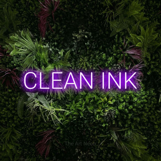 Purple LED neon sign reading "Clean Ink" against a lush garden wall with pink flowers for tattoo studio décor