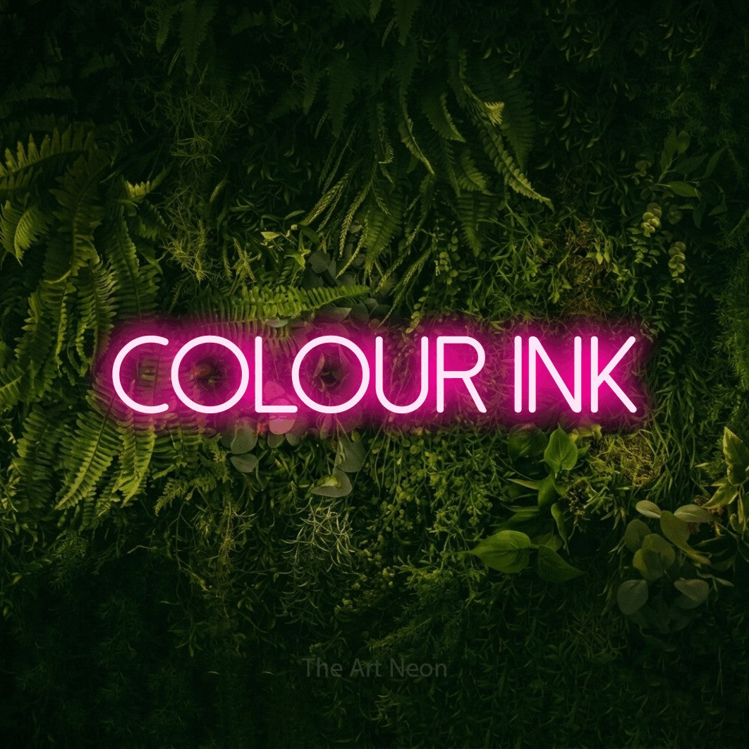 Hot pink LED neon sign reading "Colour Ink" against a moss-covered green wall for tattoo studio décor