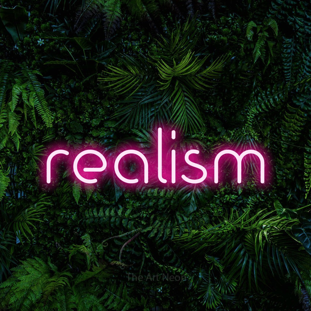 Hot pink LED neon sign reading "Realism" against a dense tropical foliage wall for tattoo studio décor