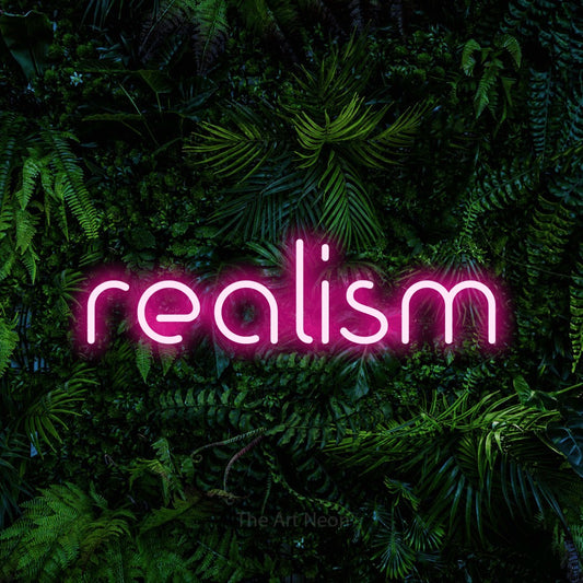Hot pink LED neon sign reading "Realism" against a dense tropical foliage wall for tattoo studio décor