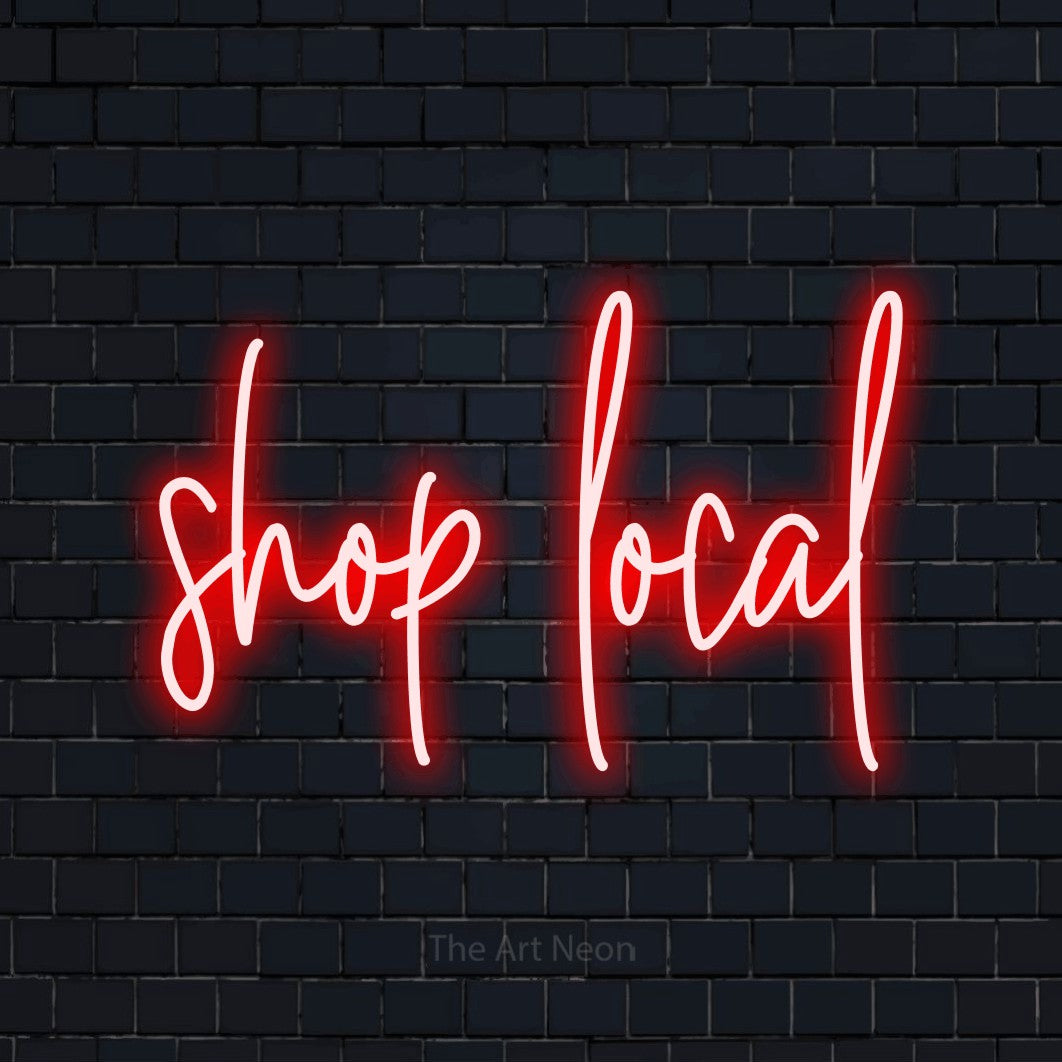 Red script-style LED neon sign reading "Shop Local" against a dark navy brick wall