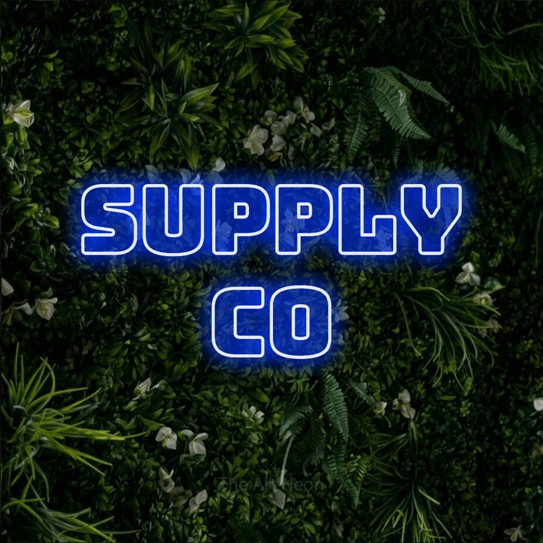 Blue outline-style LED neon sign reading "Supply Co" against a leafy green wall