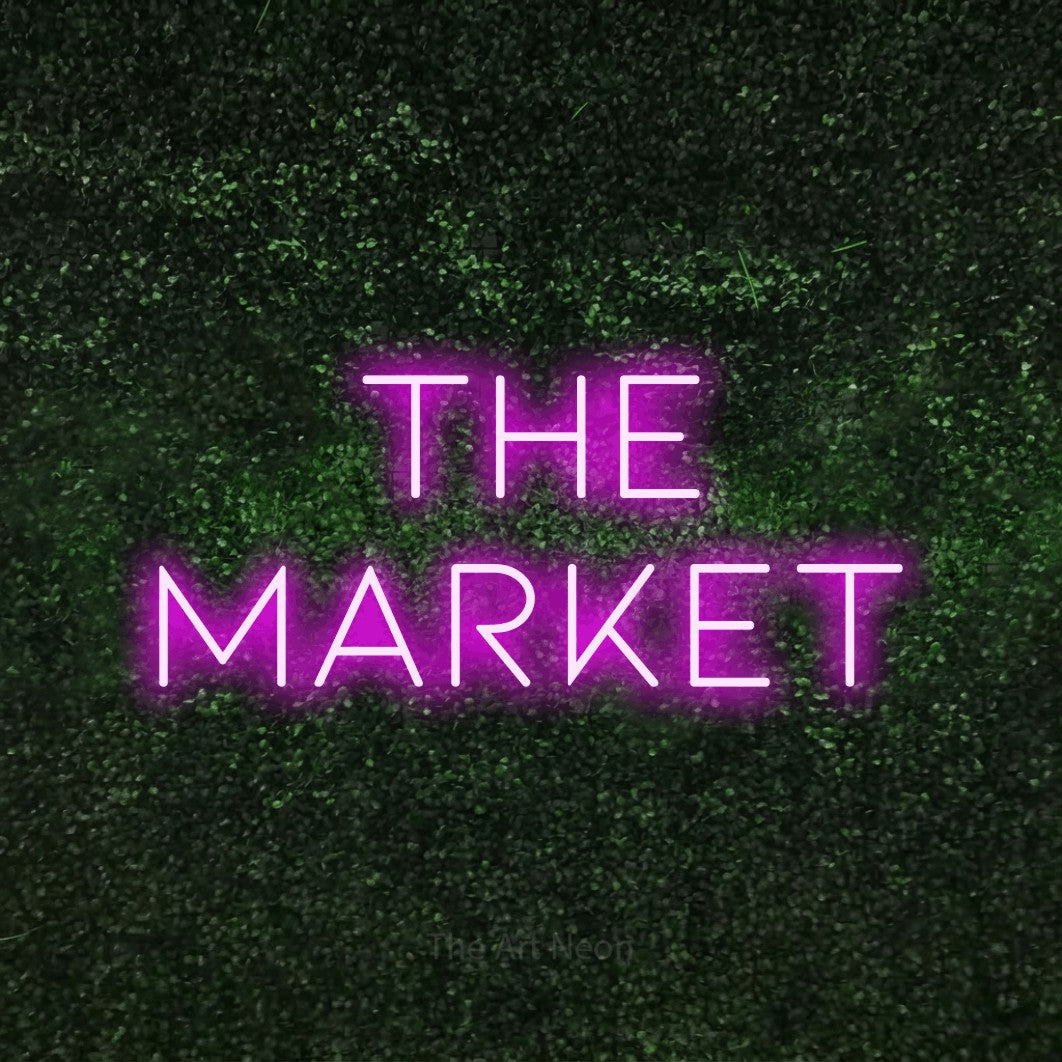 Pink LED neon sign reading "The Market" against a textured green moss wall