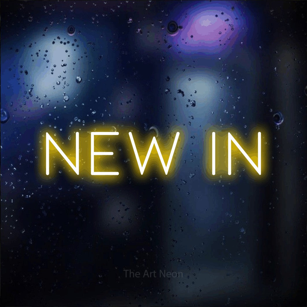Yellow LED neon sign reading "New In" against a dark blue bokeh background